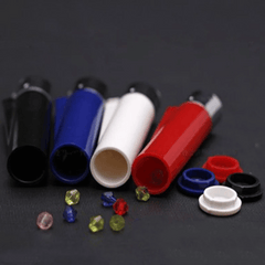Pocket lighter cases in black, blue, white and red, opened with their screw caps