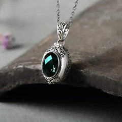 Oval locket necklace in Green, teal stone in an ornate silver-tone frame on its chain